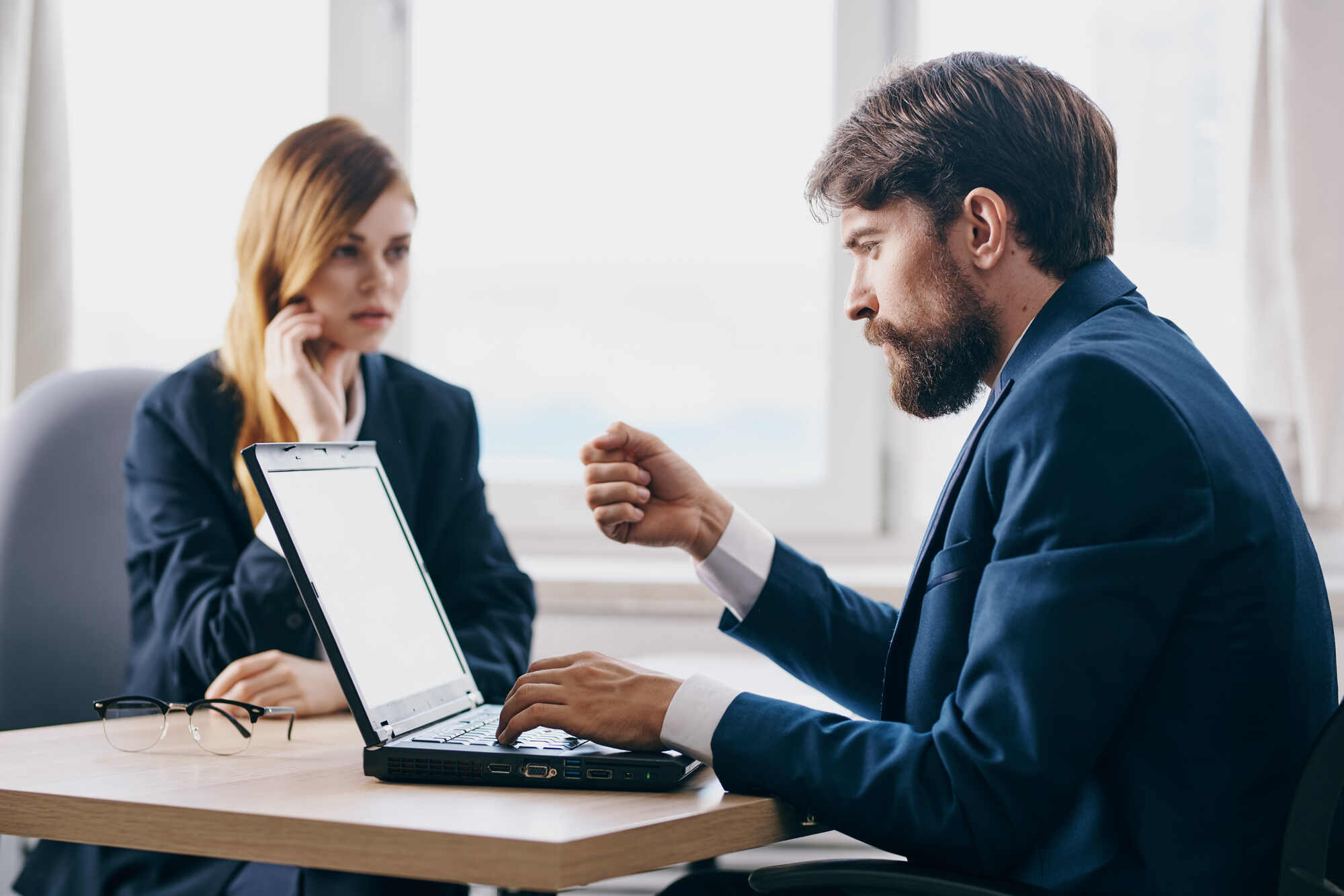 business man and woman in the office in front of a laptop career network officials