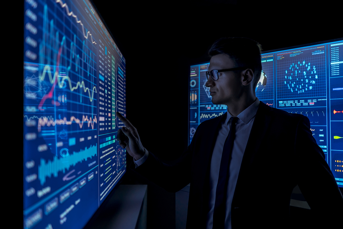 The young businessman working on a sensor screen in the dark room